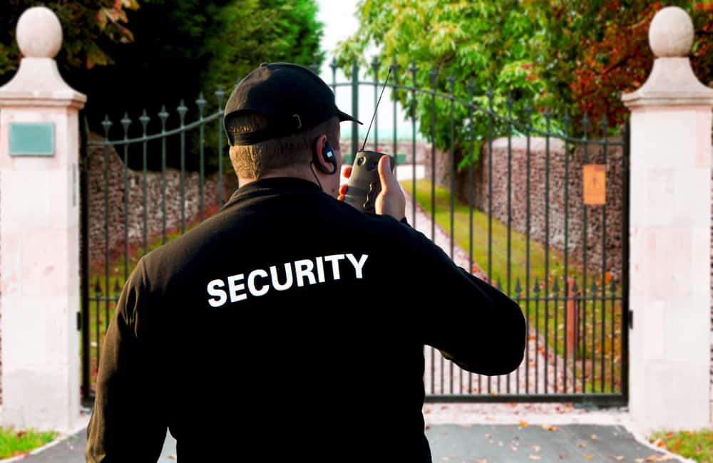 Security Guard In Front of a Gated Entry